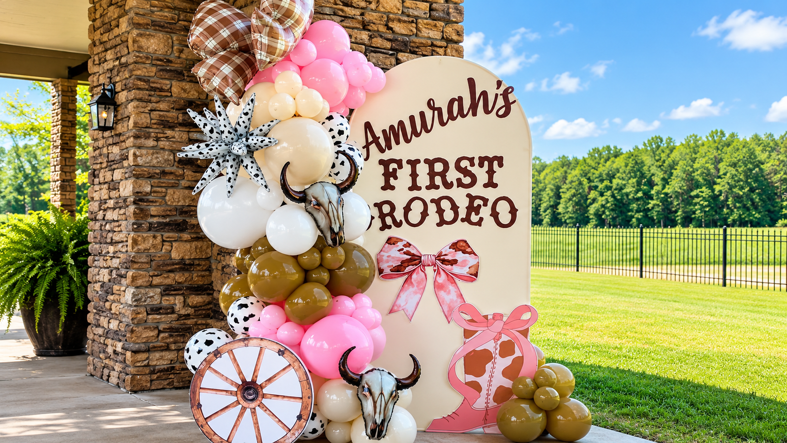 First Rodeo birthday backdrop with pink, cream and cow print balloon garland
